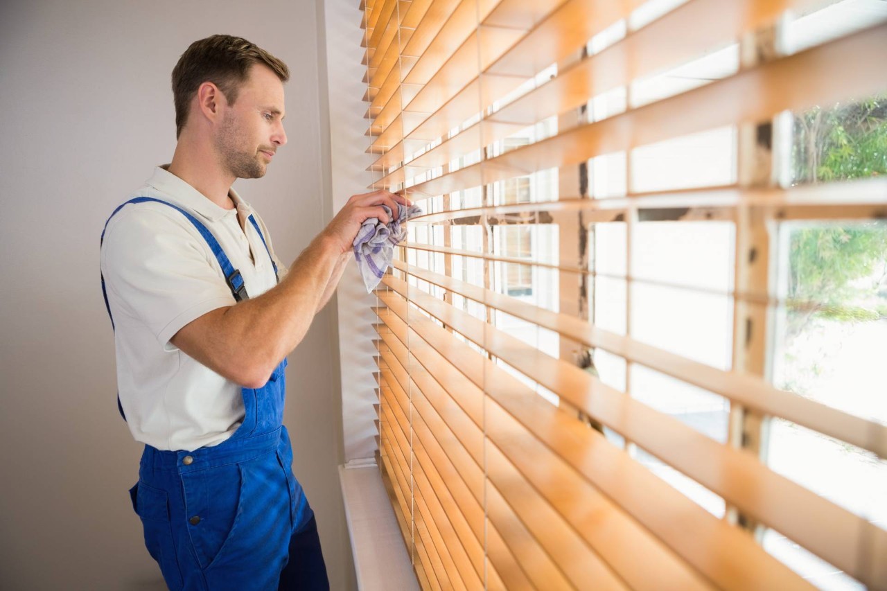 Someone cleaning a set of wooden blinds near Newburgh, New York (NY) 
