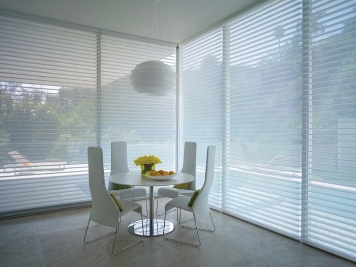 A minimalist dining room with ceiling light fixture.